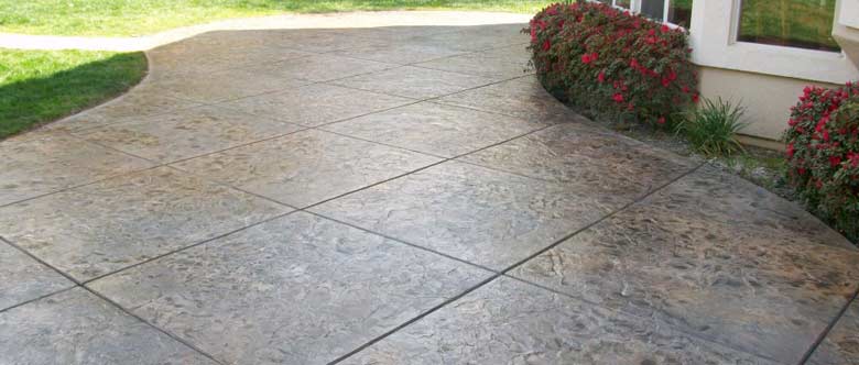 stamped concrete patio beside a garden